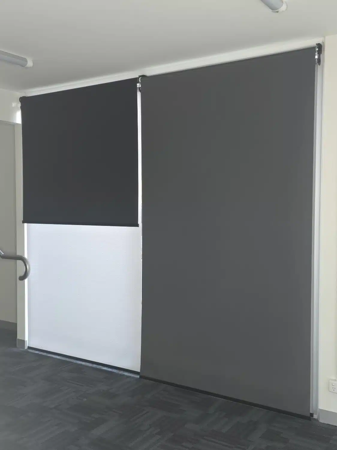 Grey and white roller blinds across full-height windows