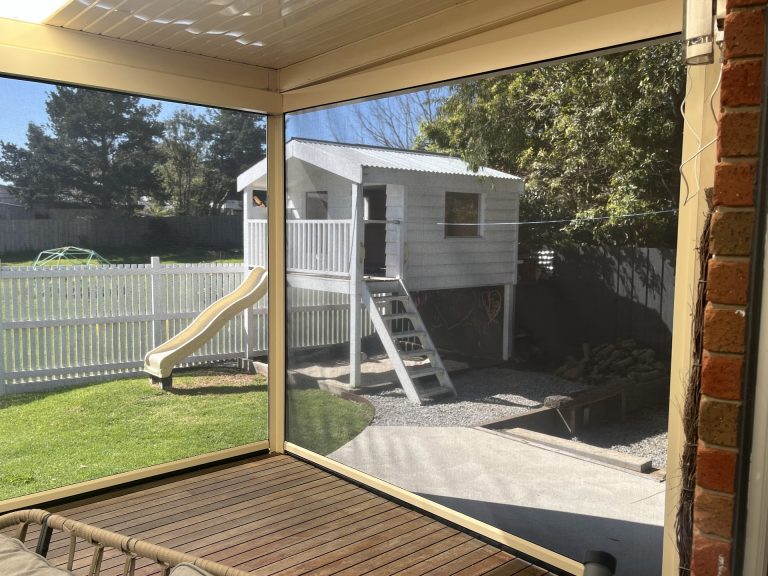 View from a covered patio through lowered outdoor mesh blinds